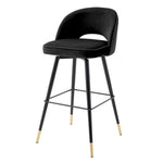 Eichholtz Bar Stool Cliff in a set of 2. Featuring black tapered legs with gold caps, the solid frame