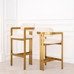 Eichholtz Bar Stool Donato a touch of vintage style to any space. Featuring a geometric brushed brass frame with