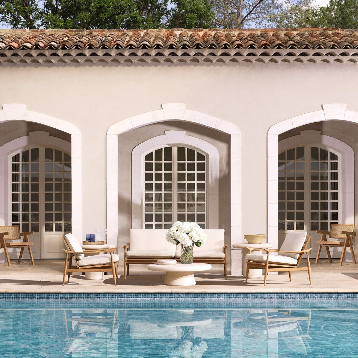 Eichholtz Outdoor Sofa Manzo wood. Featuring a luxurious off-white Flores outdoor fabric cushion set, this sofa is perfect for