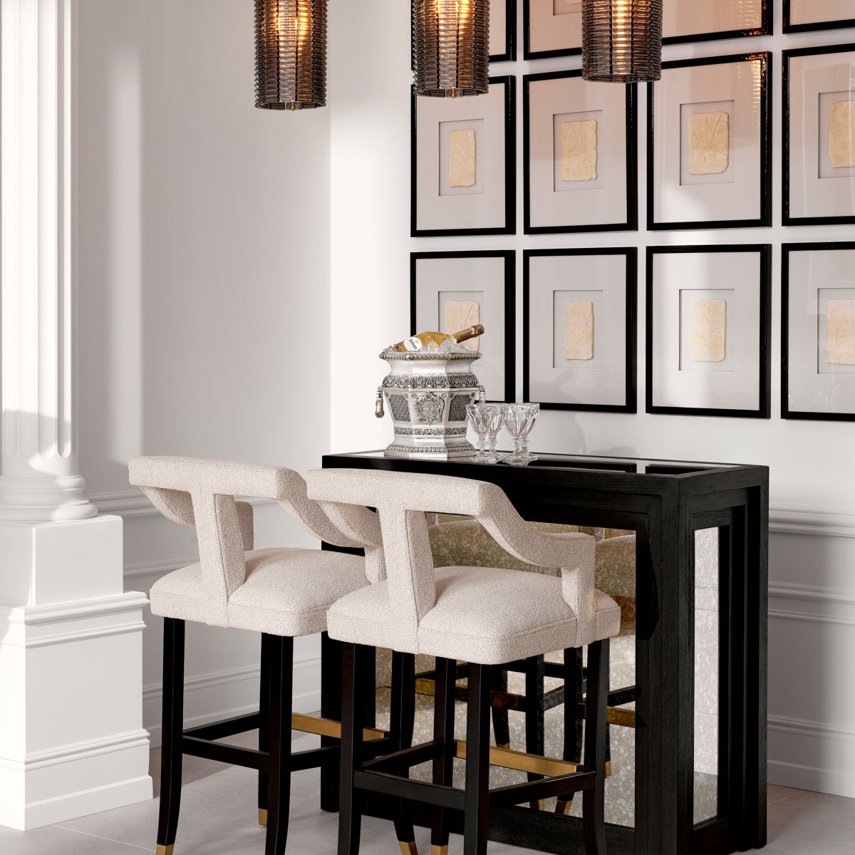 The Bar Metropolitan styled in an elegant room with cream bar stools, a silver champagne bucket, and gallery wall — part of The Met x Eichholtz collection