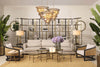 A curated Eichholtz living-room vignette — cream sofa, brass étagère, tiered chandelier — the kind of specification work the Designer Trade Program supports.