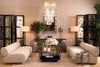 A curated Eichholtz living-room vignette — cream boucle seating, symmetric mirrored consoles, layered brass accents — the kind of welcome the Tivoli Village showroom is built for.