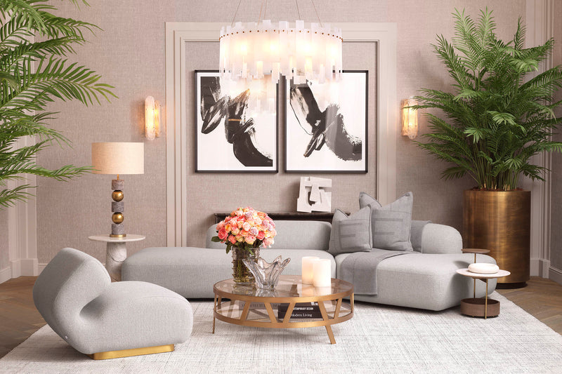 A neutral Eichholtz living room — curved grey sofa, crystal chandelier, and layered room styling