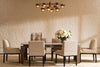 A real dining-room vignette — a rectangular dining table with six upholstered dining chairs around it and a statement chandelier overhead.