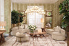 A curated Eichholtz living room — curved cream sofas, sage botanical wallpaper, and a gold globe chandelier.
