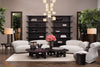A curated Eichholtz library and study vignette — dark shelving units, floor lamps, and low lounge seating.