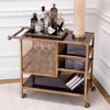 Trolley Sterling styled as a drinks station — brass frame, black glass shelves with bottles and decanters, white paneled walls