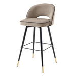 Eichholtz Bar Stool Cliff in a set of 2. Featuring black tapered legs with gold caps, the solid frame