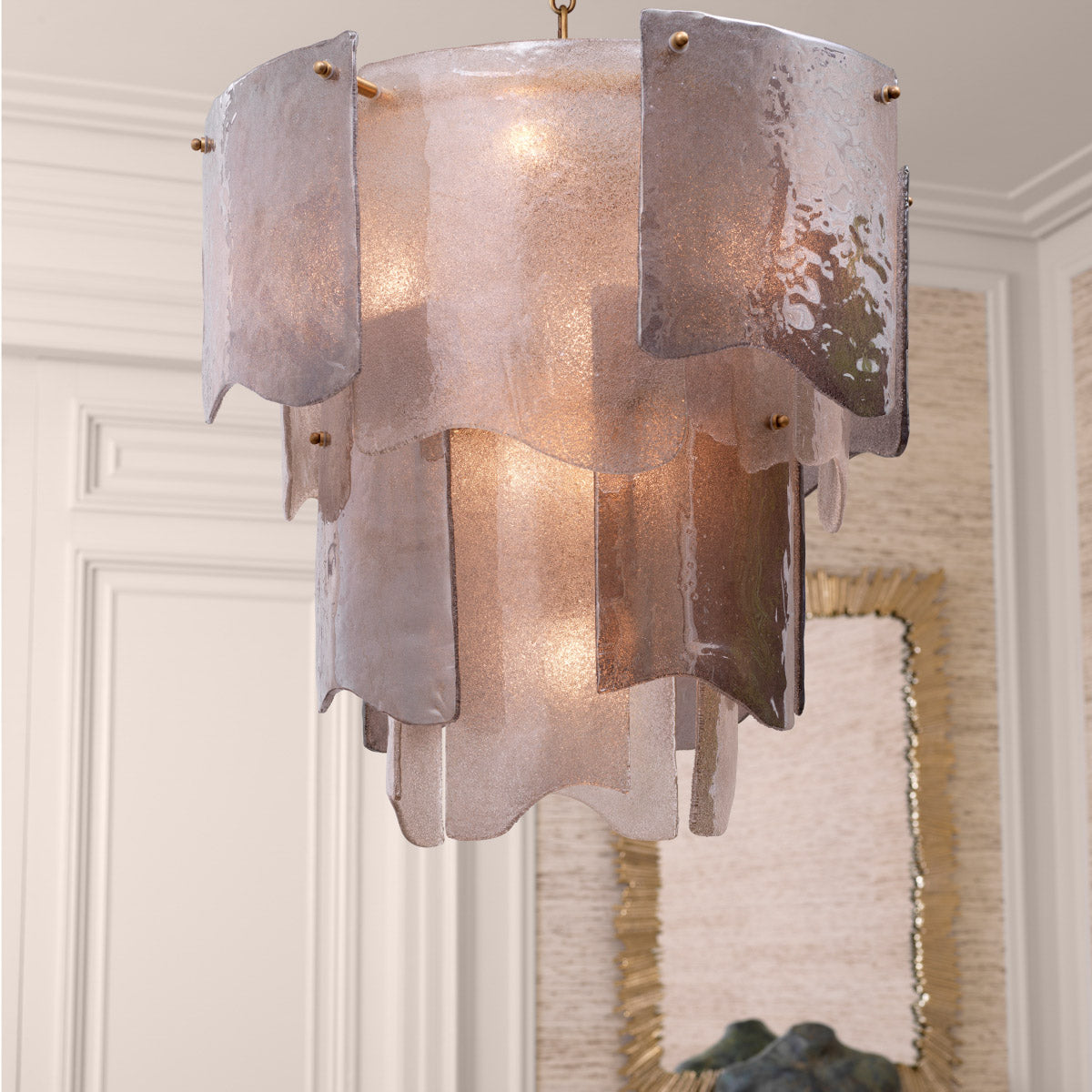 Eichholtz Chandelier Asinara S in varying colors softly diffuses light, while the antique brass finish bestows a timeless elegance.