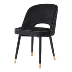 Eichholtz Dining Chair Cliff black tapered legs with gold caps, the solid frame holds an armless back that is