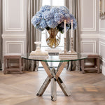 Eichholtz Dining Table Triumph home. Combining a highly polished stainless steel base with a smooth glass tabletop, it is