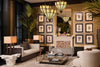 Luxury living room with deep moody wall tones, sculptural upholstered seating, gallery wall of framed artwork, faceted pendant lighting, metallic accents, and greenery in a refined European interior design.