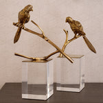 Eichholtz Object Morgana set of 2 figurine is provided with a vintage brass finish and sits on an acrylic cubicle base.