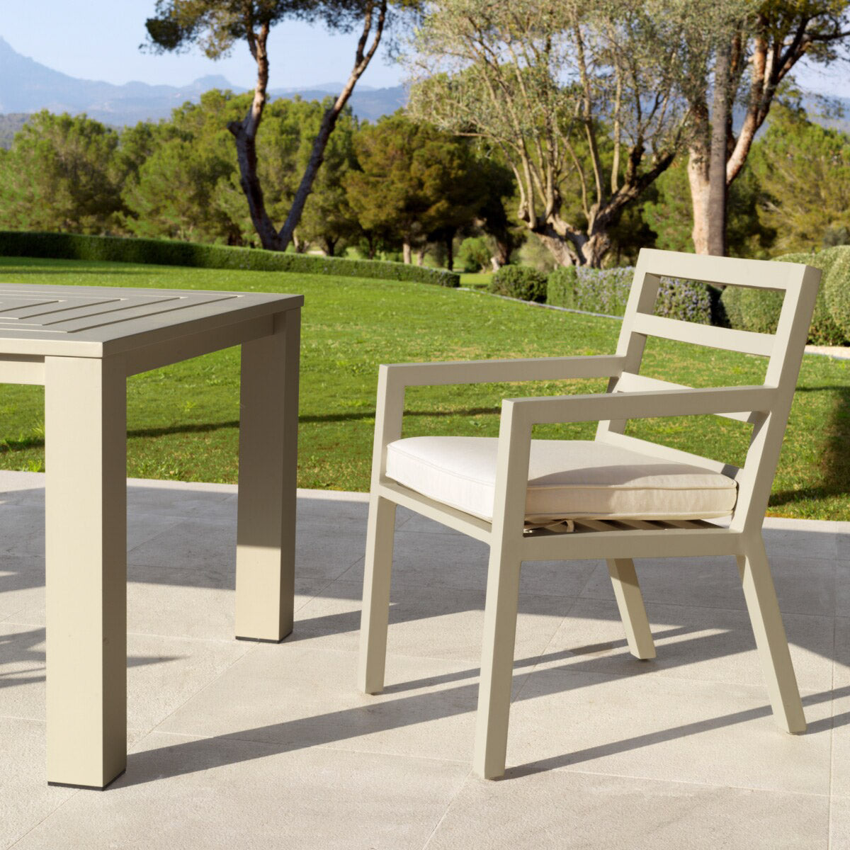Eichholtz Outdoor Dining Chair Delta complement Dining Table Vistamar, this sand finish dining chair with arms features a sleek silhouette.