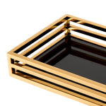 Eichholtz Tray Ersa table arrangements. Featuring a black glass bottom shelf and open-sided gold finish surround, this rectangular